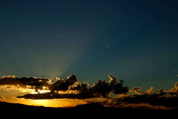 istock Cloudy Urban Sunset with Buildings and Trees Silhouetted 1158532658