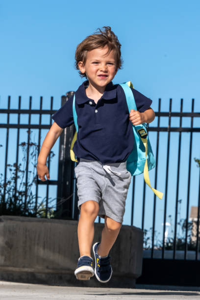 学校に戻って、小さな男の子は、学校の最初の日に走って - little boys preschooler back to school backpack ストックフォトと画像