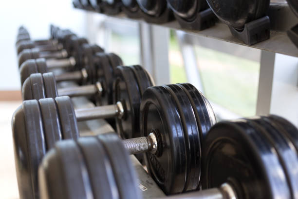 istock Heavy black metal dumbbells lying in a row, closeup 1158534323