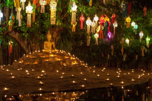 istock Buddha statue surrounded by candles and colorful lanterns. 1158534378