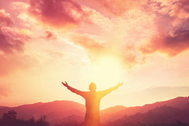 copy space of man hand raising on top of mountain and sunset sky abstract background. freedom travel adventure and business victory concept. vintage tone filter effect color style. - belief in god imagens e fotografias de stock