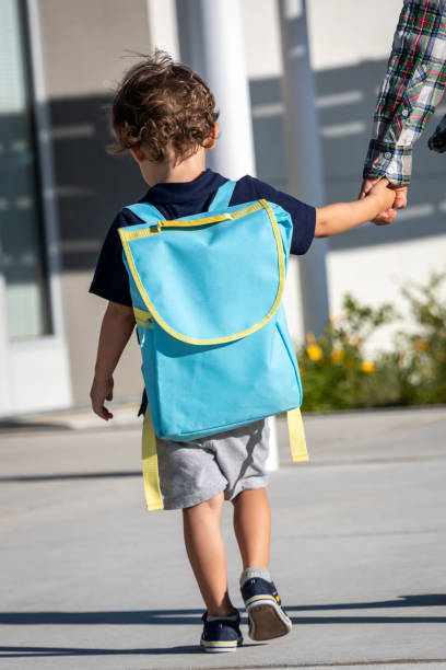 back to school, little boy child walking to his first day of school with his mom - little boys preschooler back to school backpack imagens e fotografias de stock