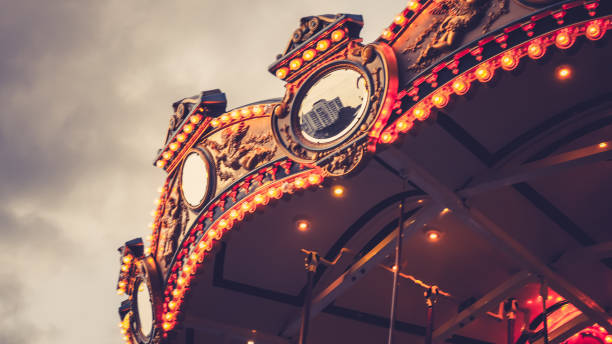 istock Merry-Go-Round (carousel) illuminated at night. reflection cityscape against evening sky in summer 1158545314
