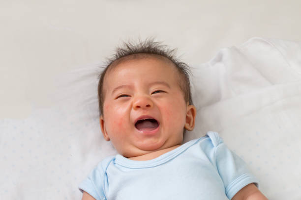 istock Happy little Asian baby smiling while lying on white bed 1158547036
