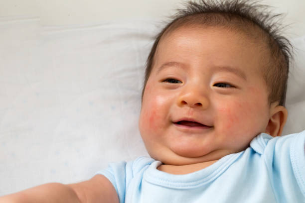 istock Happy little Asian baby smiling while lying on white bed 1158547060