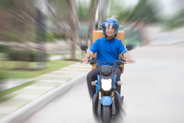 istock Delivery boy on scooter with parcel box driving fast in rush. Courier delivering express by motorcycle 1158547743