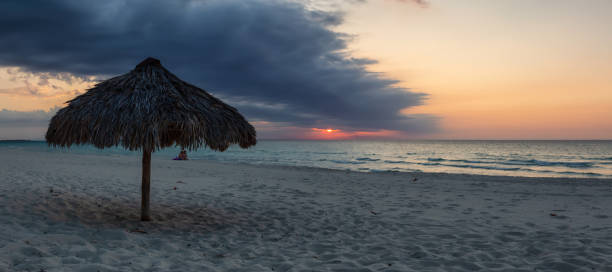 Beautiful panoramic view of the sandy beach during a dramatic cloudy sunset. Taken in Varadero, Cuba.