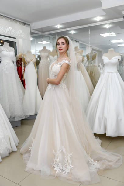istock Attractive young bride choosing wedding dress in wedding salon 1158555064