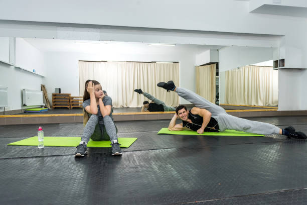 istock Young and sportive man making stretching exercises in gym 1158555474
