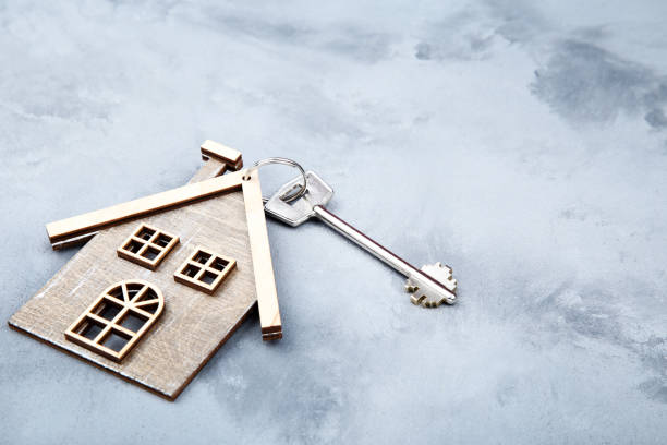 istock Silver key with house symbol on gray background 1158557140
