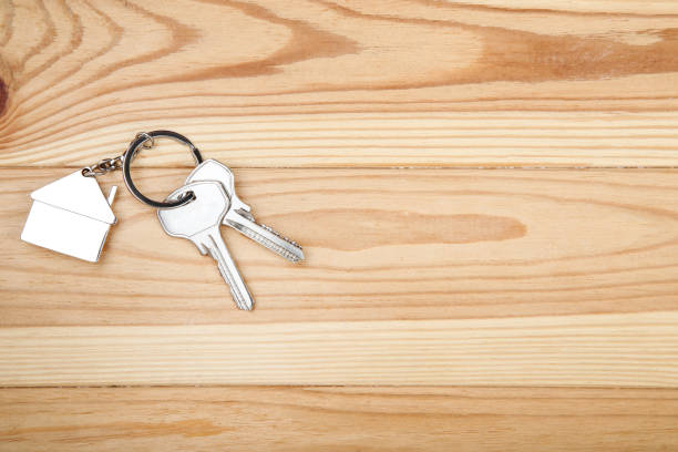 istock Silver keys with house symbol on brown wooden table 1158557307