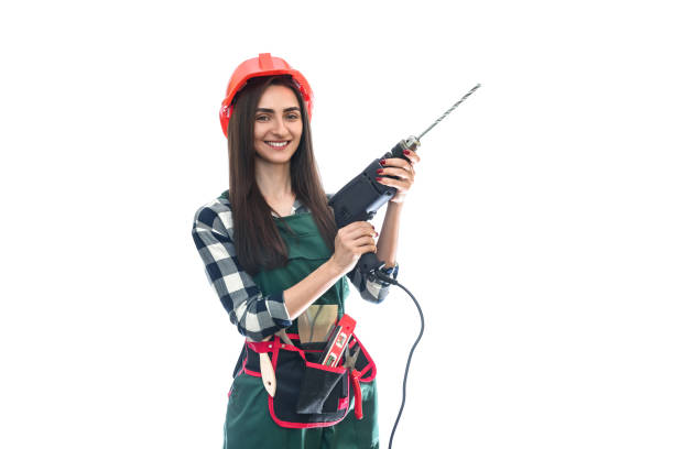 istock Beautiful woman in coverall holding drill machine isolated on white 1158557950