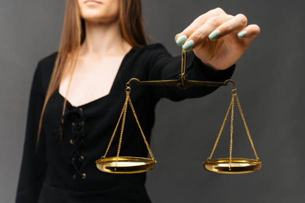 istock Serious woman holding the justice scale on dark background 1158557975