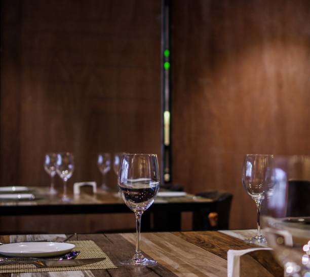 istock Empty wine glasses on restaurant table with wooden wall background 1158558172