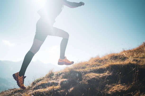 istock female cross country runner huge step back lit in mountains sunshine back lit 1158558215