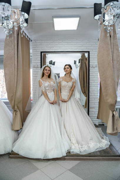 istock Happy brides in wedding dresses posing in salon 1158558382