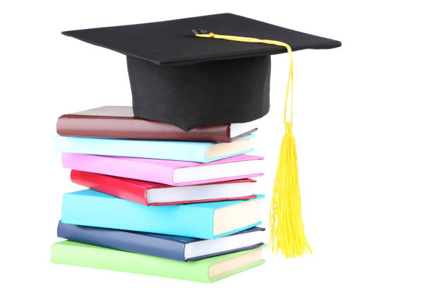 istock Graduation cap with books isolated on white background 1158558695