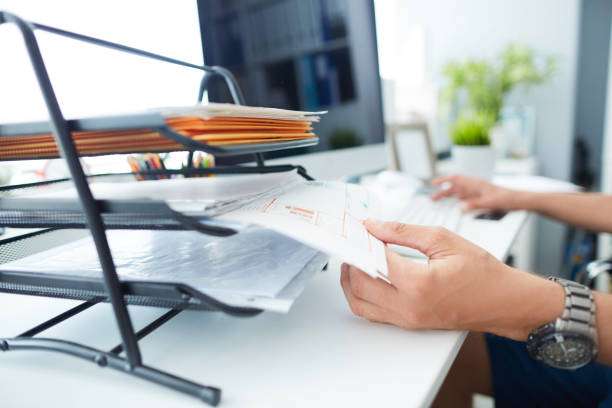 istock Close-up of a man's hand pulling files from office shelves. 1158559690