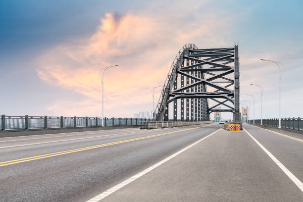 istock steel bridge and road with dusk sky 1158560186