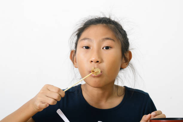 Asian girl eating spaghetti food box from convenient store, modern lifestyle concept.