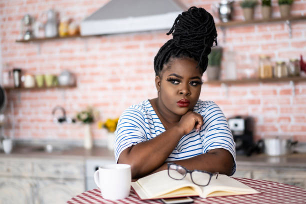 istock African woman standing home alone, suspicious 1158561108