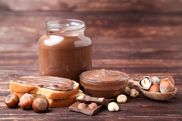 istock Bread with melted chocolate and hazelnuts on brown wooden table 1158561520