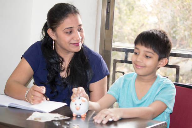 istock Mother teaching son to save money for future education expenses 1158562520