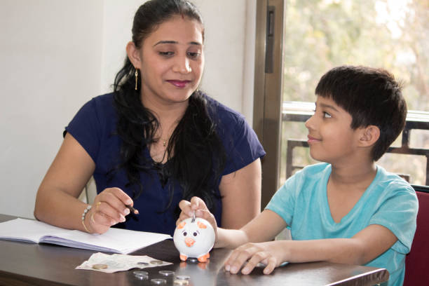 istock Mother teaching son to save money 1158565844