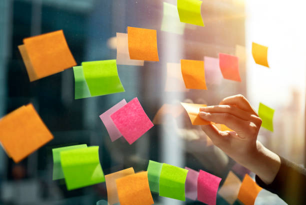 istock Young businesswoman working with stickers note on glass window 1158570247