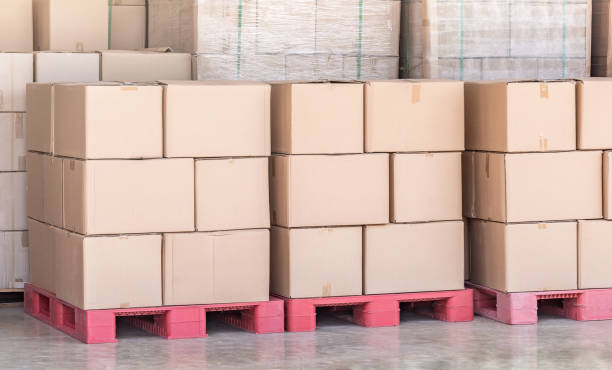 Stack of goods carton boxes on red pallet at logistics warehouse