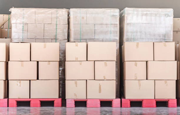 istock Stack of goods carton boxes on red pallet at logistics warehouse 1158570371