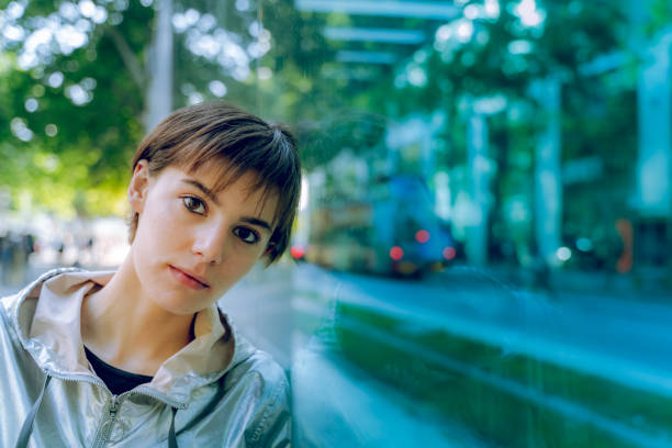 Thoughtful young woman leaning on glass