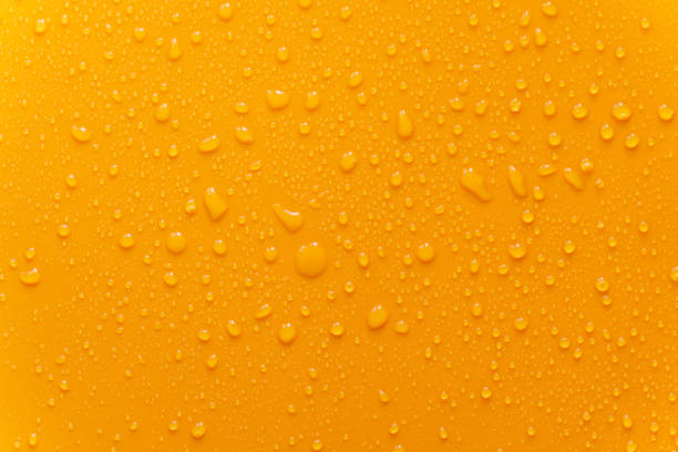 istock water drop texture close-up on orange matte background. 1158572712