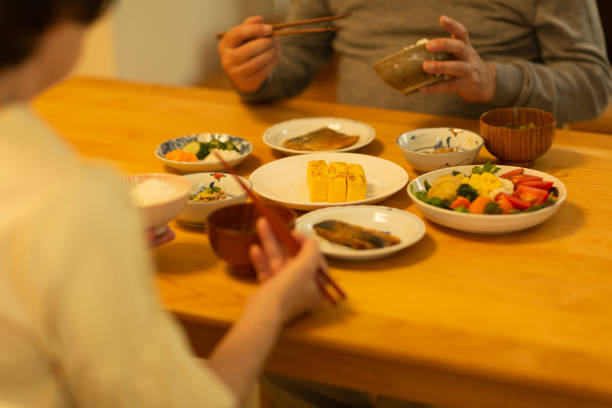夕食を食べるシニアカップル - 食卓 ストックフォトと画像