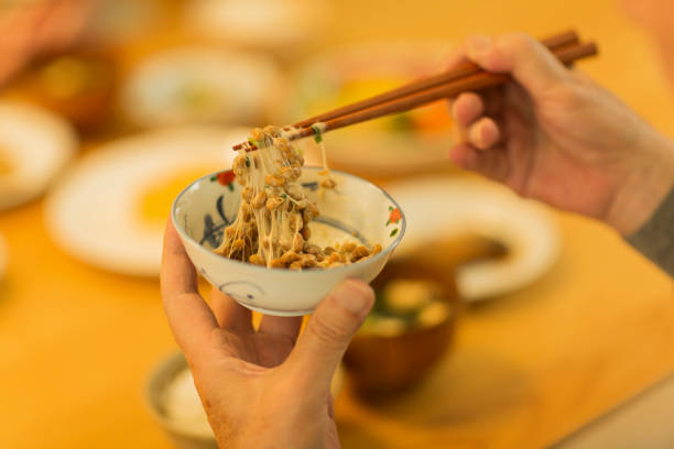 senior man eten natto tijdens het diner - natto stockfoto's en -beelden