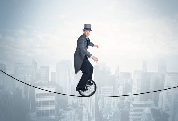istock Brave guy riding a monocycle on a rope above cityscape 1158574632
