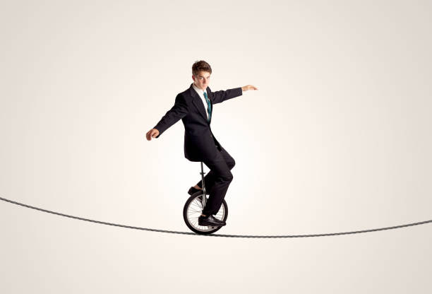 istock Extreme business man riding unicycle on a rope 1158574663