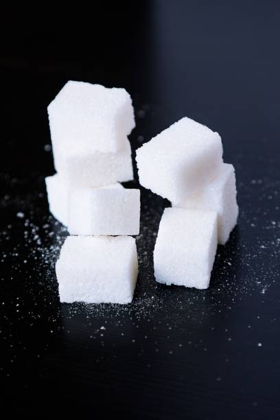 istock Sugar. Sweet cubes on black background 1158578807