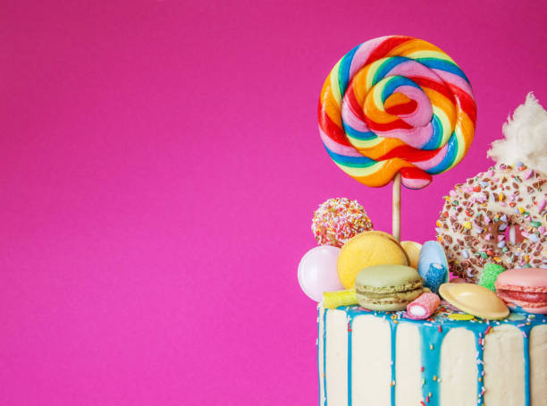 istock Colorful candy drip cake, pink background, right sided 1158580054