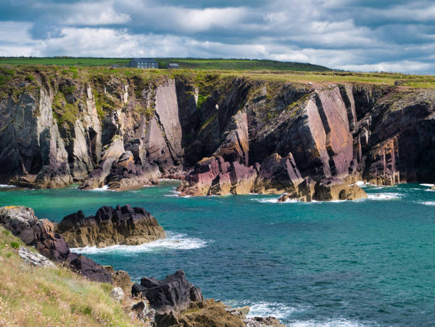 gekippte schichten aus roten sandstein-sedimentfelsen aus der kambrium-zeit in st non es bay am pembrokeshire coastal path, in der nähe von st david es in wales, uk - wales south wales coastline cliff stock-fotos und bilder