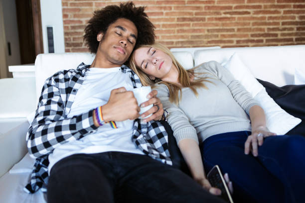istock Relaxed young couple who has fallen asleep while watching TV on the couch at home. 1158580804