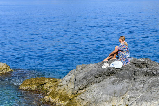 istock Woman on the rocky beach. 1158580826