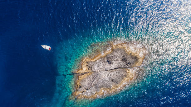 vue aérienne de dessus d'une île déserte avec le bateau blanc. rivage rocheux de l'île de zannone près de ponza, italie. eau claire bleue le jour ensoleillé. - lazio photos et images de collection
