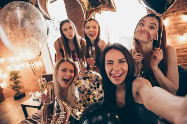 Close up photo beautiful five she her chic ladies little drunk clink wineglasses beverage, tongue out mouth funny make take selfies speak talk tell skype share news festive night evening room indoors
