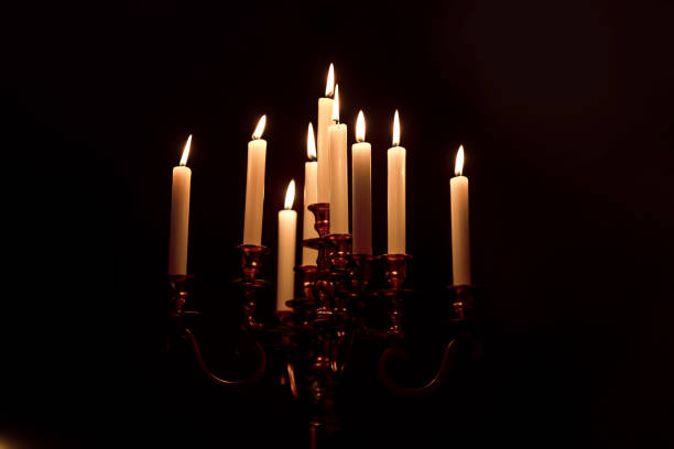 istock burning old candle vintage bronze Silver candlestick. Isolated Black Background 1158592204