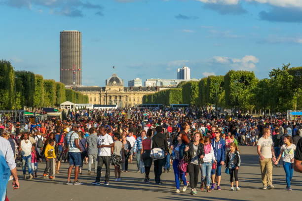 Paris/France - July 25th, 2015: Crowd in Champ de Mars with the Military School (École Militaire) in the background and the Montparnasse Tower in the distance