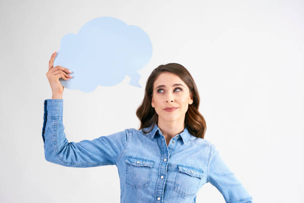 istock Woman with thought bubble looking up in studio shot 1158595741
