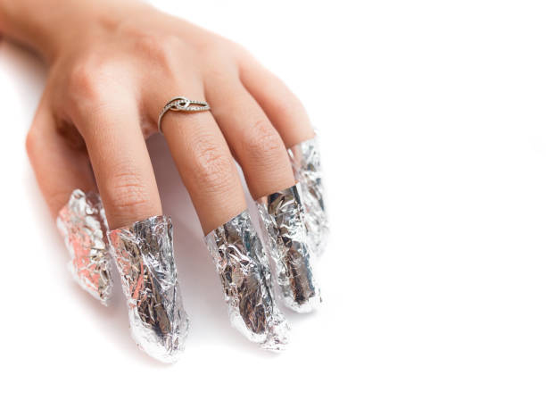 eliminación del esmalte de uñas de gel con una lámina. aislado sobre blanco. - fingernail acrylic women beauty fotografías e imágenes de stock