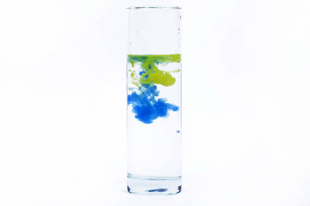 istock Blue and yellow paint fall in a glass with water 1158602453