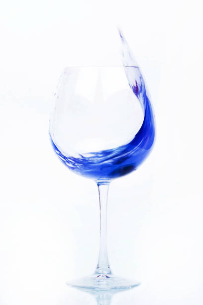 Blue water splashes in a wineglass